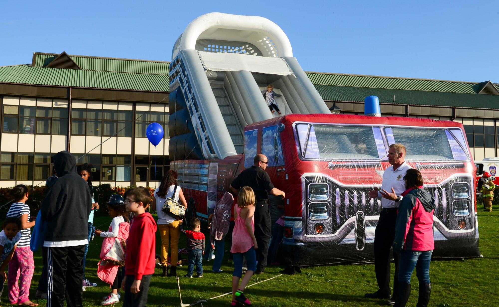 Liberty Wing children stand in line for a bouncy castle at Royal Air Force Lakenheath, England, Oct. 9, 2015. The 48th Civil Engineer Squadron firefighters held a National Fire Prevention Week festival at Lakenheath Elementary School to teach fire safety and prevention to Liberty Wing Airmen and their families. (U.S. Air Force photo by Senior Airman Dawn M. Weber/Released)