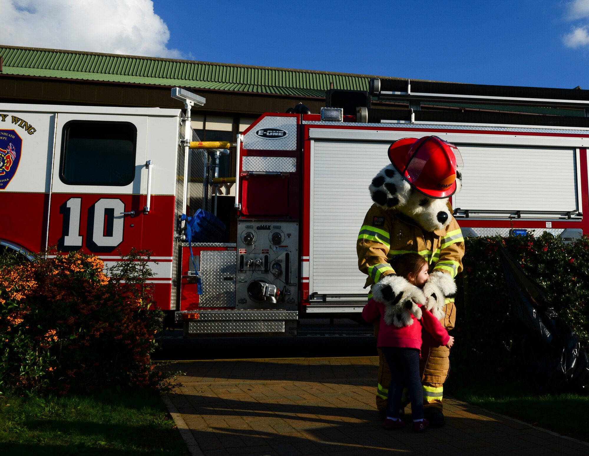 A child hugs Sparky the Firedog at Royal Air Force Lakenheath, England, Oct. 9, 2015, as part of National Fire Prevention Week. Liberty Airmen and their families attended to learn about fire safety, toured a fire truck and try on fireman gear. (U.S. Air Force photo by Senior Airman Dawn M. Weber/Released)