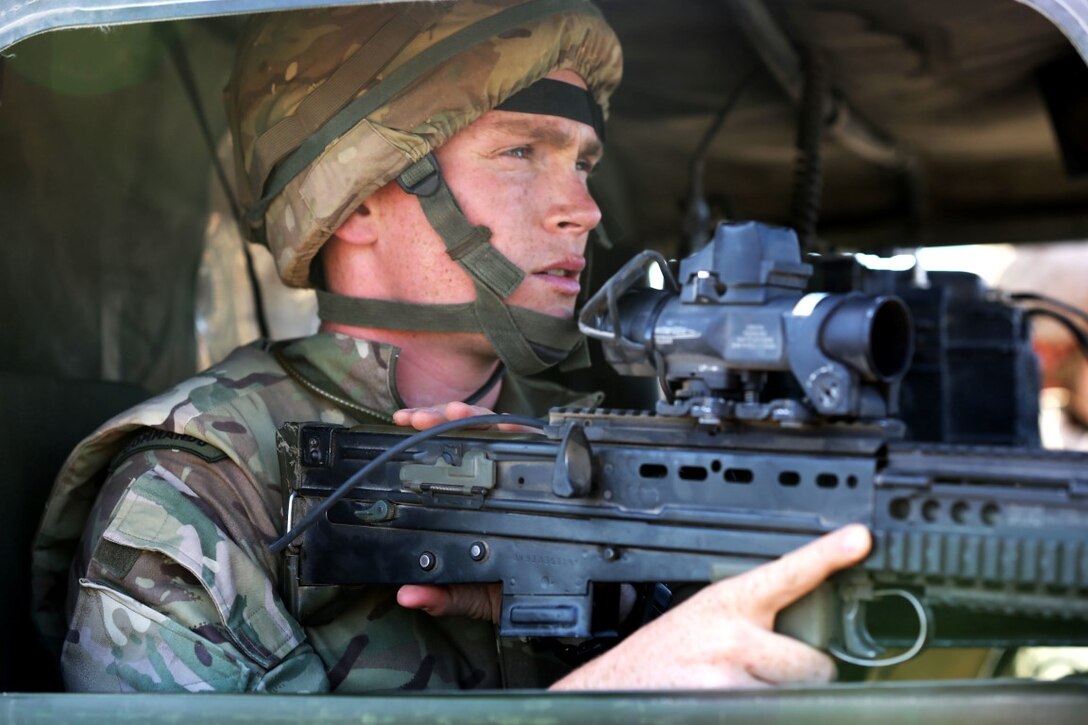 Captain Paul King, the officer liaison with 42 Commando Group, British Royal Marines, observes long range targets from a HUMVEE during Exercise Black Alligator 2015 aboard Marine Air Ground Combat Center Twentynine Palms, Calif., Sept. 30, 2015. The joint exercise allowed the British to employ Company A, 1st Tank Battalion, 1st Marine Division, integrating them into their own scheme of maneuver to engage a variety of different targets. (U.S.Marine Corps photo by Cpl. Demetrius Morgan/RELEASED)