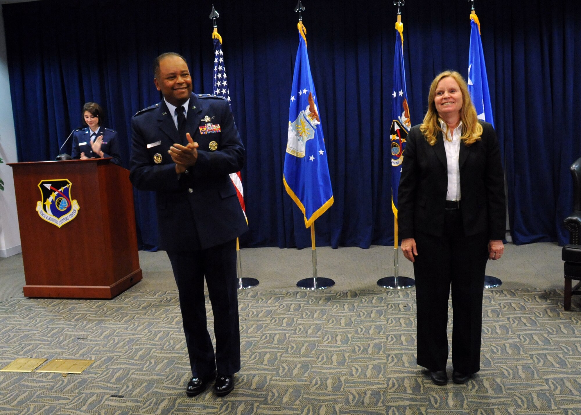 Lt. Gen. Samuel Greaves, Space and Missile Systems Center commander and Air Force program executive officer for Space, leads the audience in applauding Dr. Claire Leon as the first director of the Launch Systems Enterprise Directorate during a stand-up ceremony Oct. 14, 2015, at Los Angeles Air Force Base, Calif. (U.S. Air Force photo/Van De Ha)