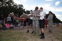 Tech. Sgt. Mark Fox (center), 902nd Security Forces Squadron NCO in charge of police services, demonstrates how security forces members can use a taser against criminals during National Night Out Oct. 6 at Joint Base San Antonio-Randolph. Each year on the second Tuesday of October, National Night Out takes place in communities across the nation to foster positive relationships between neighbors and law enforcement members.