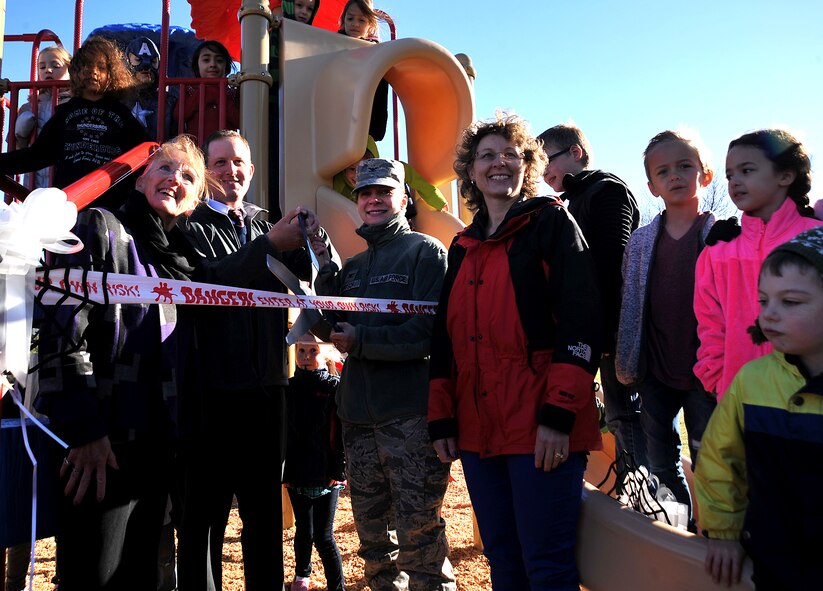 Timothy Haddock, Service Credit Union branch manager, and Col. Therese Bohusch, 319th Medical Group commander, cut the ribbon for the new playground donated by Service Credit Union to Twining Elementary and Middle School on Grand Forks Air Force Base, North Dakota, Oct. 15, 2015. The playground was designed for children ages 2-12 and for children with disabilities.(U.S. Air Force photo/Airman 1st Class Bonnie Grantham/Released)