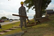 Staff Sgt. Michael Wallace of the 507th Civil Engineer Squadron removes landscaping timbers located next to a soon-to-be demolished stairway Oct. 3, 2015, at Tinker Air Force Base, Okla. The stairway was removed as a safety precaution, since the stairway cracked over time and became uneven and unsafe. (U.S. Air Force photo/Senior Airman Krystin Trosper)