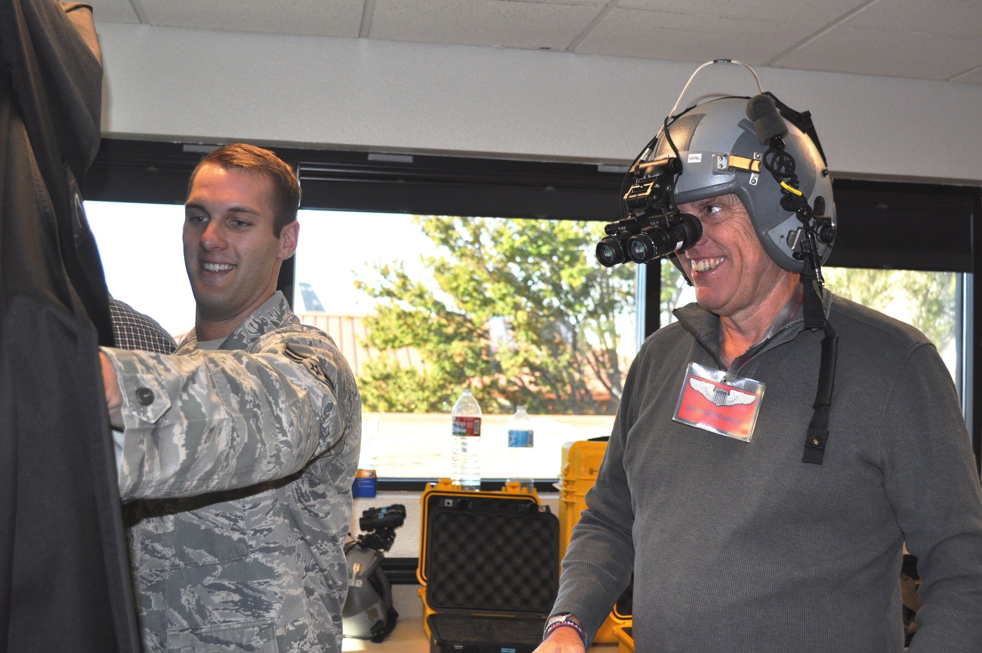 TRAVIS AIR FORCE BASE, Calif. -- Mr. John Steiner, honorary commander for the 9th Refueling Squadron, and an officer with the California Highway Patrol, gets strapped into a flight helmet by Senior Amn. Lindsy Zeter, a life support specialist with the 60th Operations Support Squadron. Steiner was one of about 55 HCCs that toured various areas of the 60th Operations Group to familiarize them with missions of the various squadrons that work as one, supporting Travis Air Force Base's flying mission of bringing hope and might around the world. (U.S. Air Force photo/Ellen Hatfield