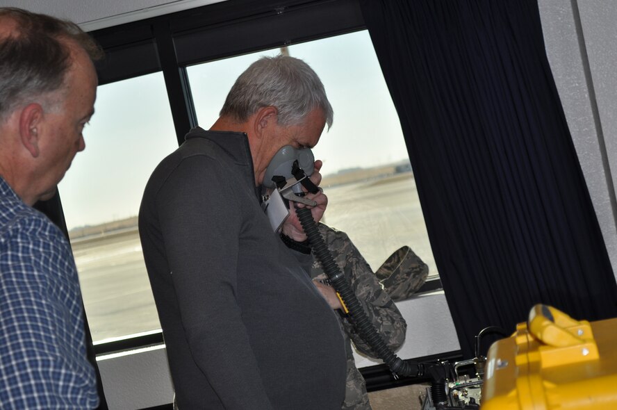 TRAVIS AIR FORCE BASE, Calif. -- Mr. John Steiner, honorary commander for the 9th Refueling Squadron, and an officer with the California Highway Patrol, gets strapped into a flight helmet by Senior Amn. Lindsy Zeter, a life support specialist with the 60th Operations Support Squadron. Steiner was one of about 55 HCCs that toured various areas of the 60th Operations Group to familiarize them with missions of the various squadrons that work as one, supporting Travis Air Force Base's flying mission of bringing hope and might around the world. (U.S. Air Force photo/Ellen Hatfield