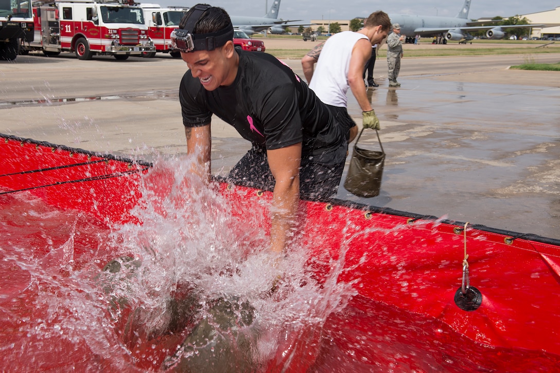 Senior Airman Nicholas Brown, 80th Operations Support Squadron air traffic controller, fills his water bags during the 6th Annual Firefighter Olympic Challenge Oct. 9, 2015. The challenge took place during fire prevention week as a means to raise awareness for fire safety and prevention. Brown's team won 1st place in the competition. (U.S. Air Force photo/Senior Airman Kyle Gese)