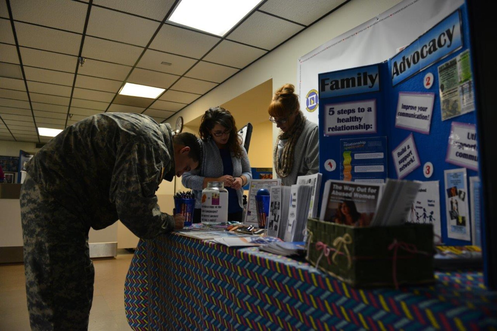 Spc. Travis Hansen, a 6th Brigade Engineer Battalion horizontal construction engineer, provides his information to Family Advocacy Program personnel to be used in a raffle. After successfully answering a series of questions on FAP programs, Hansen earned five raffle tickets. The winner of the raffle will receive a popular relationship-focused self-help book. (U.S. Air Force photo/Airman 1st Class Kyle Johnson)
