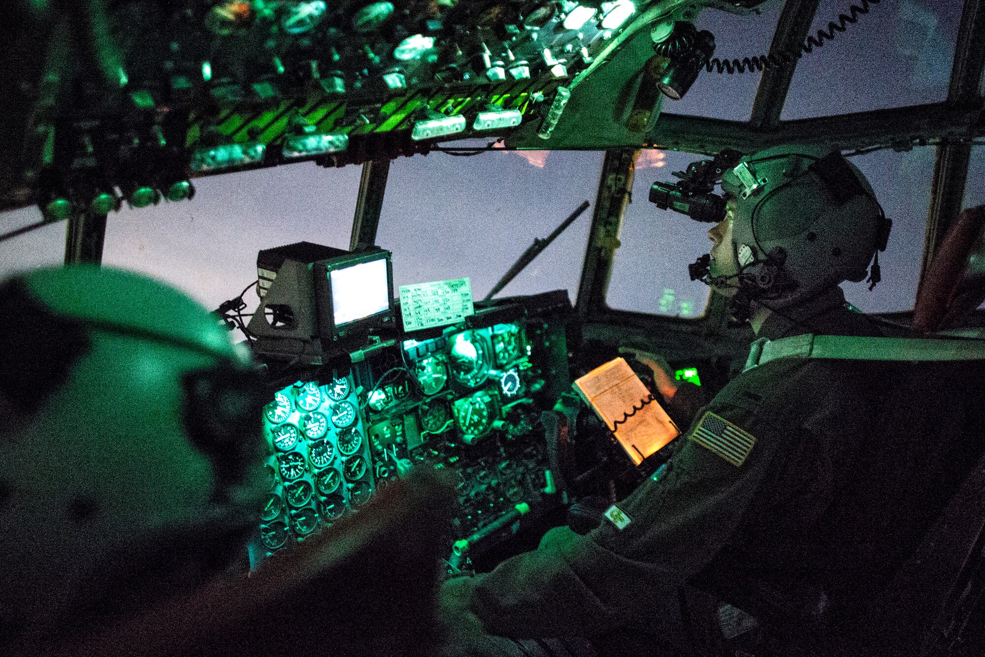 1st Lt. Randall Kanzelmeyer, 36th Airlift Squadron c-130 Hercules pilot, wears a night vision goggle during a training mission above Yokota Air Base, Japan, Oct. 14, 2015. Yokota aircrews regularly conduct night flying operations to ensure they’re prepared to respond to a variety of contingencies throughout the Indo-Asia Pacific region. (U.S. Air Force photo by Osakabe Yasuo/Released)