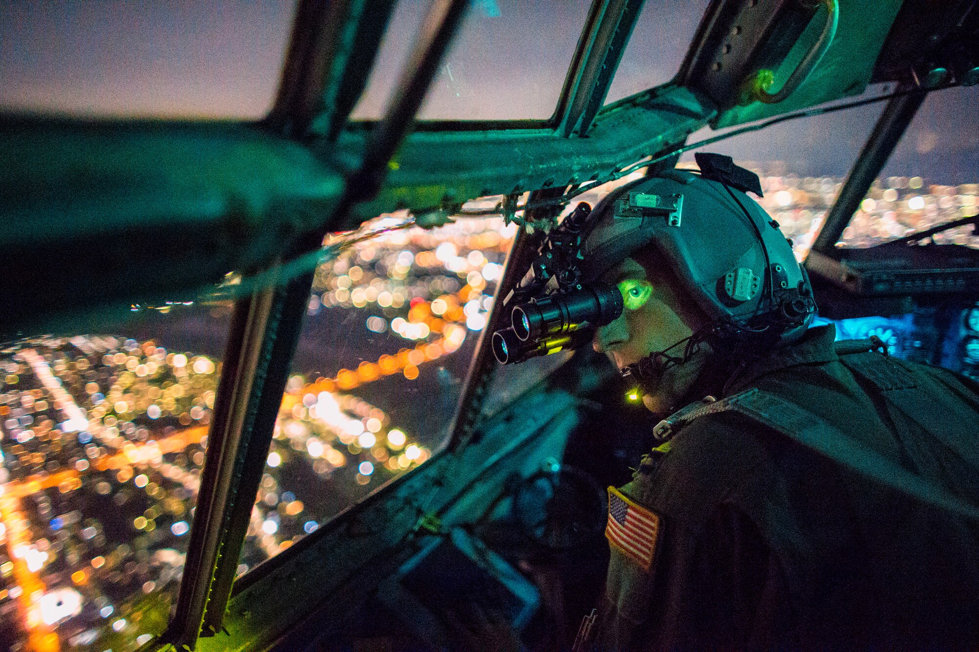Capt. Thomas Bernard, 36th Airlift Squadron C-130 Hercules pilot, performs a visual confirmation with a night vision goggles during a training mission over the Kanto Plain, Japan, Oct. 14, 2015. Yokota aircrews regularly conduct night flying operations to ensure they’re prepared to respond to a variety of contingencies throughout the Indo-Asia Pacific region. (U.S. Air Force photo by Osakabe Yasuo/Released)