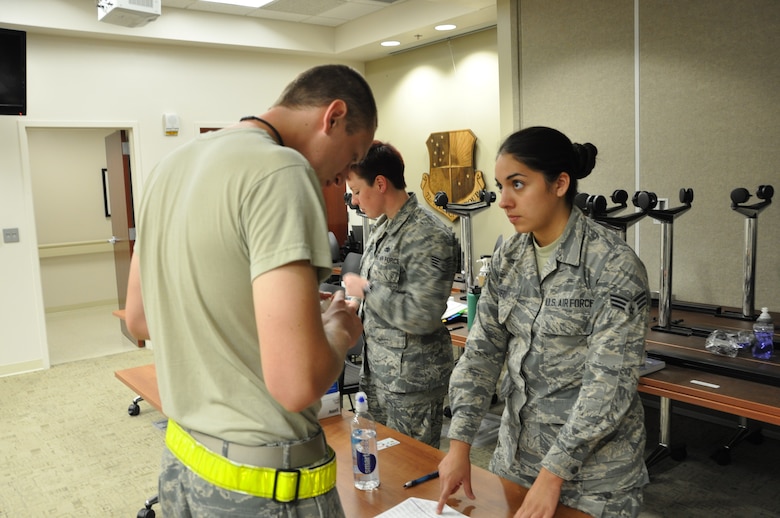 Senior Airman Eloisa Paez of the 507th Medical Squadron’s Drug Demand Reduction team waits as an Airman verifies his information on his urine sample during urinalysis testing Oct. 3, 2015, at Tinker Air Force Base, Okla. The 507th MDS is required to test 100 percent of the Reservist population each year. (U.S. Air Force photo/Tech. Sgt. Charles Taylor)