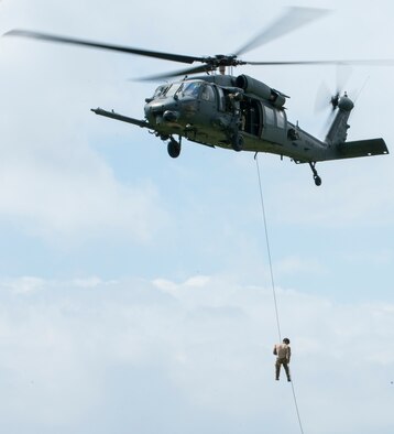 A pararescueman fast-ropes from a helicopter Oct. 3, 2015, at Kadena Air Base, Japan. The Airmen demonstrated rescue capabilities of the 31st and 33rd Rescue Squadrons during Rescue Fest, a yearly rescue tactics education event. (U.S. Air Force photo/Airman 1st Class Nicholas Emerick)