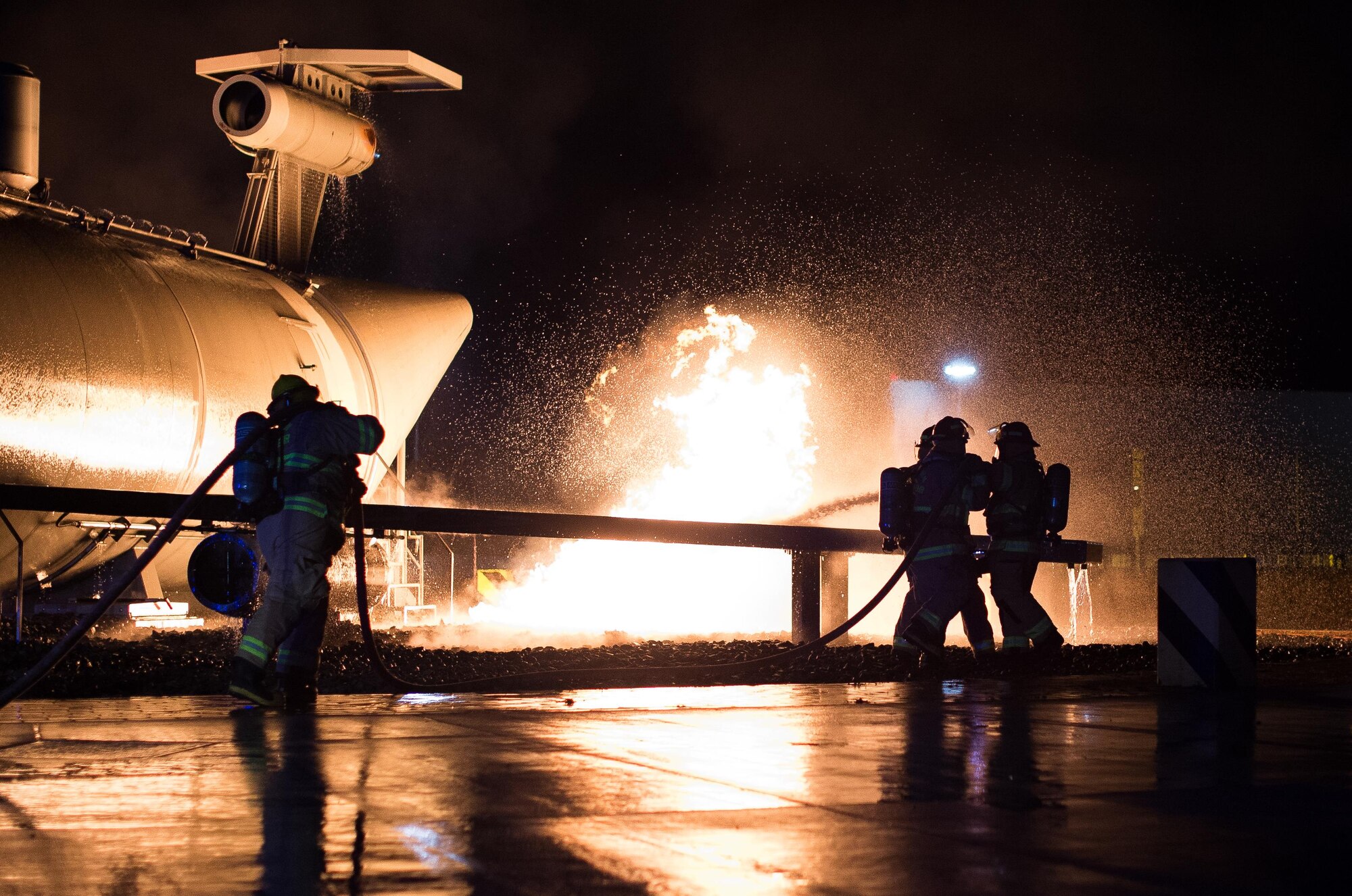 Firefighters and base leadership demonstrate extinguishing an aircraft fire Oct. 8, 2015, at Ramstein Air Base, Germany. As part of Fire Prevention Week, families visited Fire Station 1 to learn about fire safety, including home-fire safety issues, fire extinguisher training and holiday safety tips. (U.S. Air Force photo/Senior Airman Damon Kasberg)
