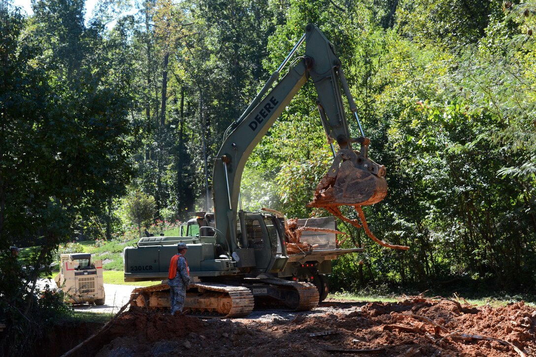 South Carolina Army National Guard soldiers operate heavy equipment to remove debris and repair a road on Botanical Parkway, West Columbia, S.C., during a statewide flood response Oct. 14, 2015. South Carolina Air National Guard photo by Airman Megan Floyd