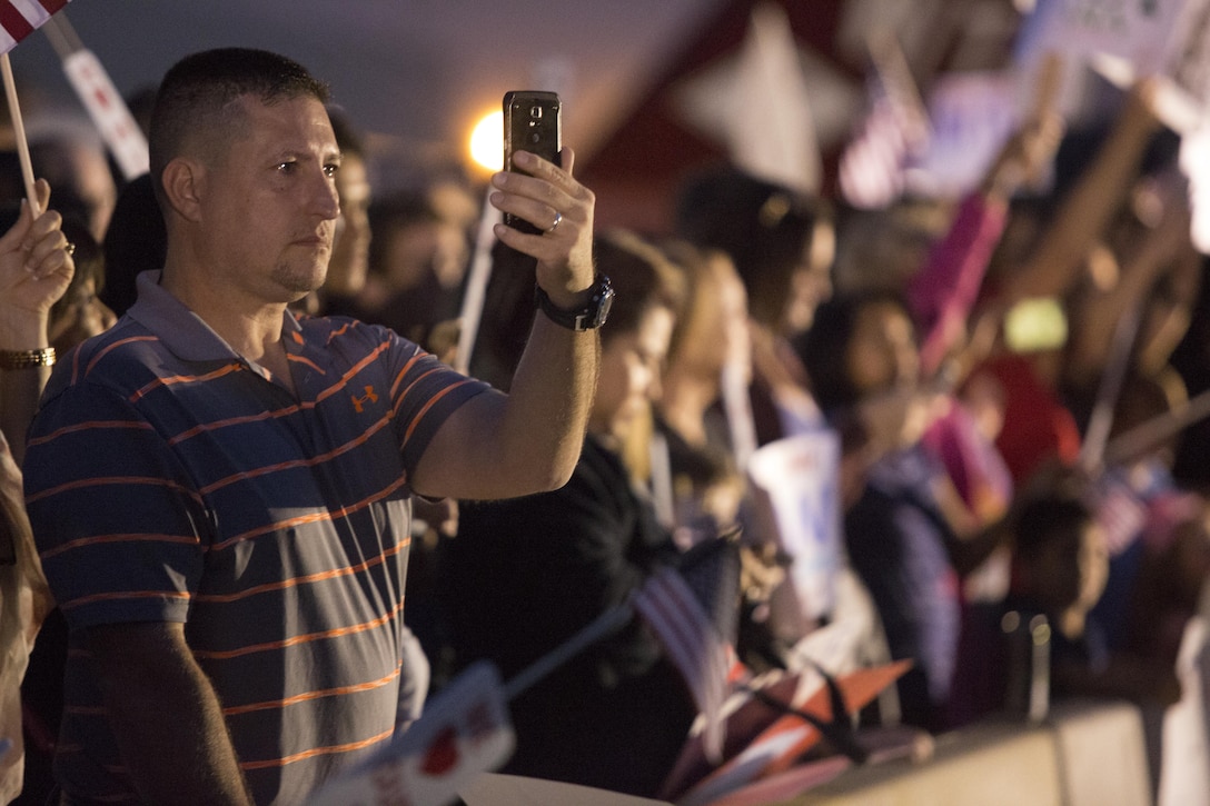 Family members take photos as Marine Fighter Attack Squadron (VMFA) 232 returns from a six-month deployment aboard Marine Corps Air Station Miramar, Calif., Oct. 16. Fellow service members, friends and family members greeted the Marines and Sailors on the flight line of MCAS Miramar. (U.S. Marine Corps photo by Sgt. Lillian Stephens/Released)