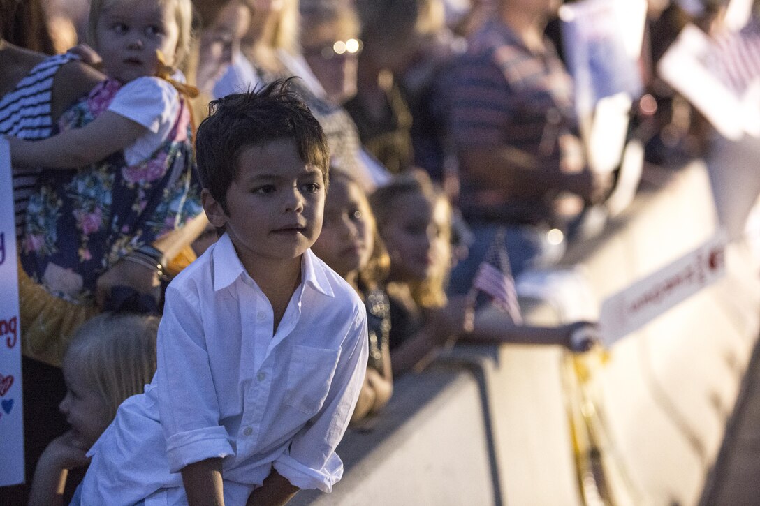 Children lean over the dividers as they await the return of Marines and Sailors with Marine Fighter Attack Squadron (VMFA) 232 aboard Marine Corps Air Station Miramar, Calif., Oct. 16. Service members, friends and family members greeted returning Marines and Sailors after a six-month deployment MCAS Miramar. (U.S. Marine Corps photo by Sgt. Lillian Stephens/Released)