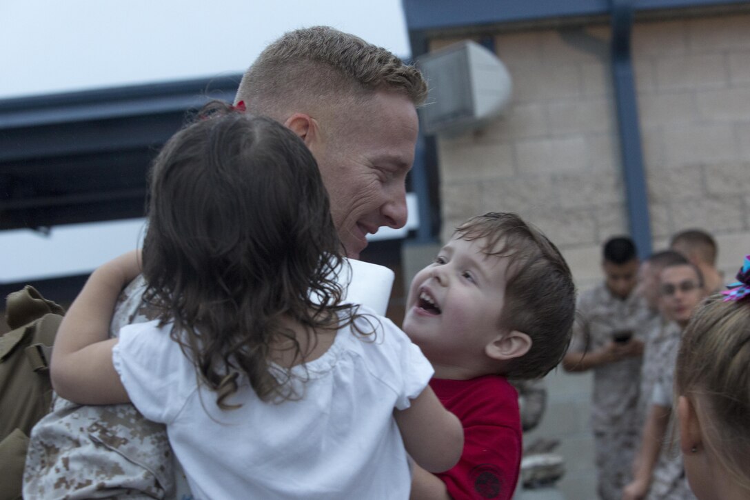 A Marine with Marine Fighter Attack Squadron (VMFA) 232 greets his children aboard Marine Corps Air Station Miramar, Calif., Oct. 16. Fellow service members, friends and family members greeted the Marines and Sailors of VMFA-232 after returning from a six-month deployment. (U.S. Marine Corps photo by Sgt. Lillian Stephens/Released)