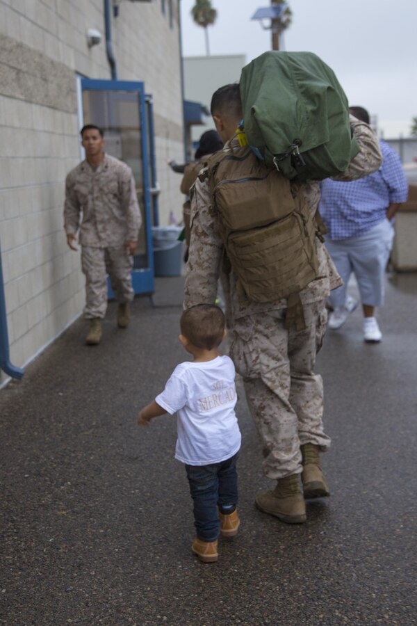 A Marine with Marine Fighter Attack Squadron (VMFA) 232 walks his son into the Passenger Terminal aboard Marine Corps Air Station Miramar, Calif., Oct. 16. Fellow service members, friends and family members greeted the Marines and Sailors on the flight line of MCAS Miramar. (U.S. Marine Corps photo by Sgt. Lillian Stephens/Released)