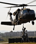 OSAN AIR BASE, South Korea Soldiers assigned to 6-52 ADA, attach a Missile Round Trainer to a UH-60L Black Hawk helicopter during sling load training at Osan Air Base, Oct. 14. Soldiers trained with flight crews from Alpha Company, 2-2 ASLT based at K-16 Air Base, Korea. 