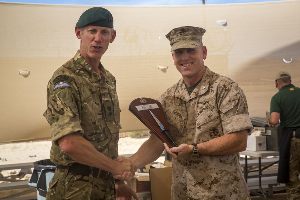 British Royal Marine Lt. Col. Richard Cantrill, commanding officer, 42 Commando, 3 Commando Brigade, presents Combat Center Chief of Staff, Col. James F. Harp, with a plaque to show his thanks for the opportunity to train aboard the installation during a barbeque lunch concluding Black Alligator 15 at Camp Wilson, Oct. 8, 2015. (Official Marine Corps photo by Lance Cpl. Levi Schultz/Released)