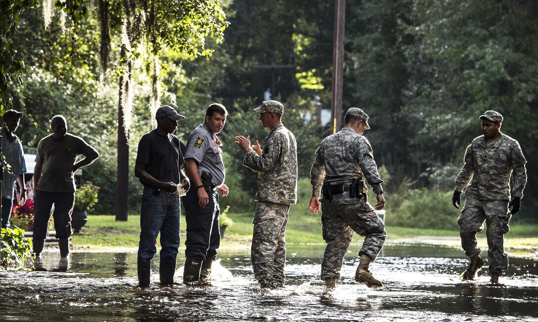 South Carolina Army National Guardsmen and local police unload sandbags to help a resident in Parkers Ferry, S.C., Oct. 9, 2015, in the aftermath of historic flooding in the state. The soldiers are with Company A, 1st Battalion, 118th Infantry Regiment. U.S. Air Force photo by Staff Sgt. Perry Aston