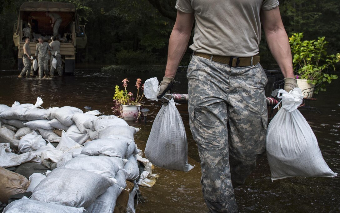 South Carolina Army National Guardsmen unload sandbags to help a resident protect his property in Parkers Ferry, S.C., Oct. 9, 2015, in the aftermath of historic flooding in the state. U.S. Air Force photo by Staff Sgt. Perry Aston