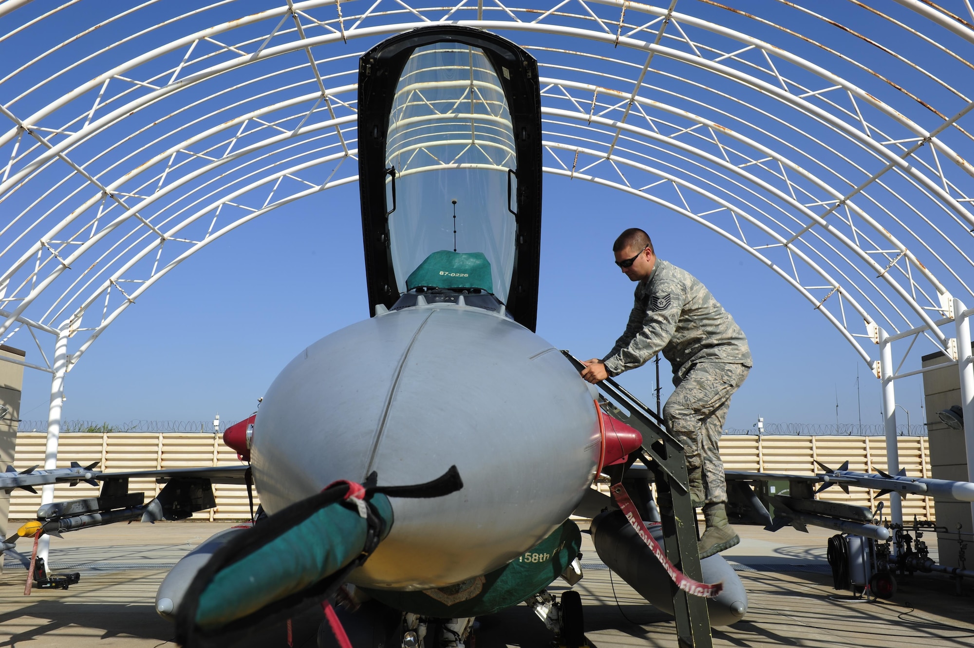 U.S. Air Force Tech. Sgt. Brett Larson, 134th Expeditionary Fighter Squadron F-16 Fighting Falcon crew chief, Vermont Air National Guard, climbs a ladder to inspect the cockpit of an F-16 at Kunsan Air Base, Republic of Korea, Oct. 6, 2015. The 134th EFS was redeployed from Kadena Air Base, Japan to Kunsan AB as part of a theater security package. Movement of TSPs into the Pacific region is a routine and integral part of U.S. Pacific Command’s force posture. (U.S. Air Force photo by Staff Sgt. Nick Wilson/Released)