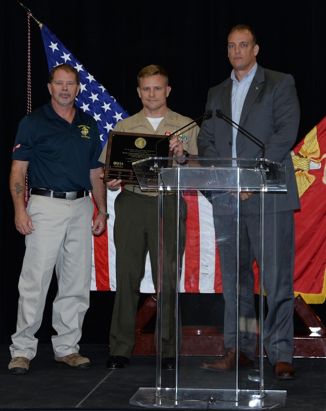 Col. Brian G. Hughes, (center) commanding officer, Blount Island Command and Marine Corps Support Facility Blount Island in Jacksonville, Fla., holds a plaque designating the organizations Voluntary Protection Program Star sites during a ceremony, Oct. 16. Jeff Churchill, (left) command safety officer, BICMD, and Brian Sturtecky, Occupational Safety and Health Administration representative, were on hand for the ceremony. 