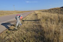 Capt. Dajon Demille, 25th Space Range Squadron, picks up paper and cigarette butts during volunteer road clean up, Friday, Oct. 9, 2015, outside Schriever Air Force Base, Colorado. Members of the 25th and 379th Space Range Squadrons participated in road cleanup which started at the Schriever Air Force Base Visitor Center and continued along Enoch Road. Demille believes even the smallest contribution matters, “It’s the little things that make a big difference.” (U.S. Air Force photo/Monique Fontenot)