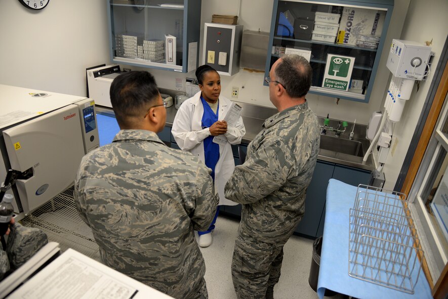 Staff Sgt. Halima Burton, 47th Medical Operations Squadron dental hygienist, explains the importance of a sterile working environment to  Brig. Gen. Lee Payne, right, Air Force Medical Operations Agency commander, and Chief Master Sgt. John Yun, Air Force Medical Operations Agency superintendent, in the dental clinic on Laughlin Air Force Base, Oct. 15, 2015. A smooth operating dental program is vital to the mission and is mandated by AFI 47-101, to be sure every Airman can readily deploy. (U.S. Air Force photo by Airman 1st Class Brandon May)