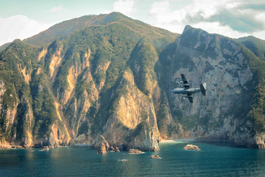 A C-130 Hercules flies over Izu peninsula, Japan, Oct. 14, 2015. Performing regular in-flight operations gives all related personnel real world experience to stay prepared for contingency situations and regular operations. (U.S. Air Force photo by Airman 1st Class Elizabeth Baker/Released)