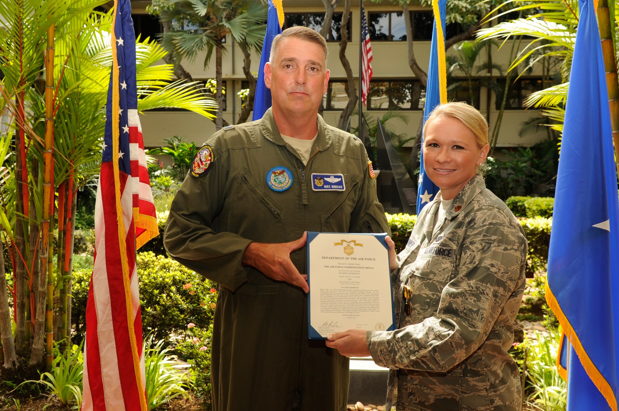 Brig. Gen. Michael Minihan presents Maj. Ashley Conner with a commendation medal for her work while supporting earthquake relief efforts in Nepal during a ceremony in the Courtyard of Heroes at the Pacific Air Force Headquarters Oct. 16. Conner, a Reservist with the 477th Fighter Group, deployed with the PACAF Joint Air Component Coordination Element to Nepal in May 2015. (U.S. Air Force/Master Sgt. Matthew McGovern)