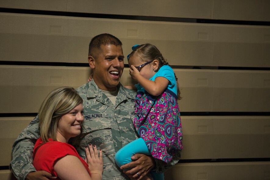 U.S. Air Force Master Sgt. Jason Delacruz, 824th Base Defense Squadron fire team leader, poses for a photo with his family during the 824th Base Defense Squadron deployment ceremony, Oct. 16, 2015, at Moody Air Force Base, Ga. The 824th BDS is part of the 820th Base Defense Group that was activated in 1997 as an exceptionally trained force protection unit of 12 Air Force Specialty Codes with an airborne capability. (U.S. Air Force photo/Senior Airman Ryan Callaghan/Released)