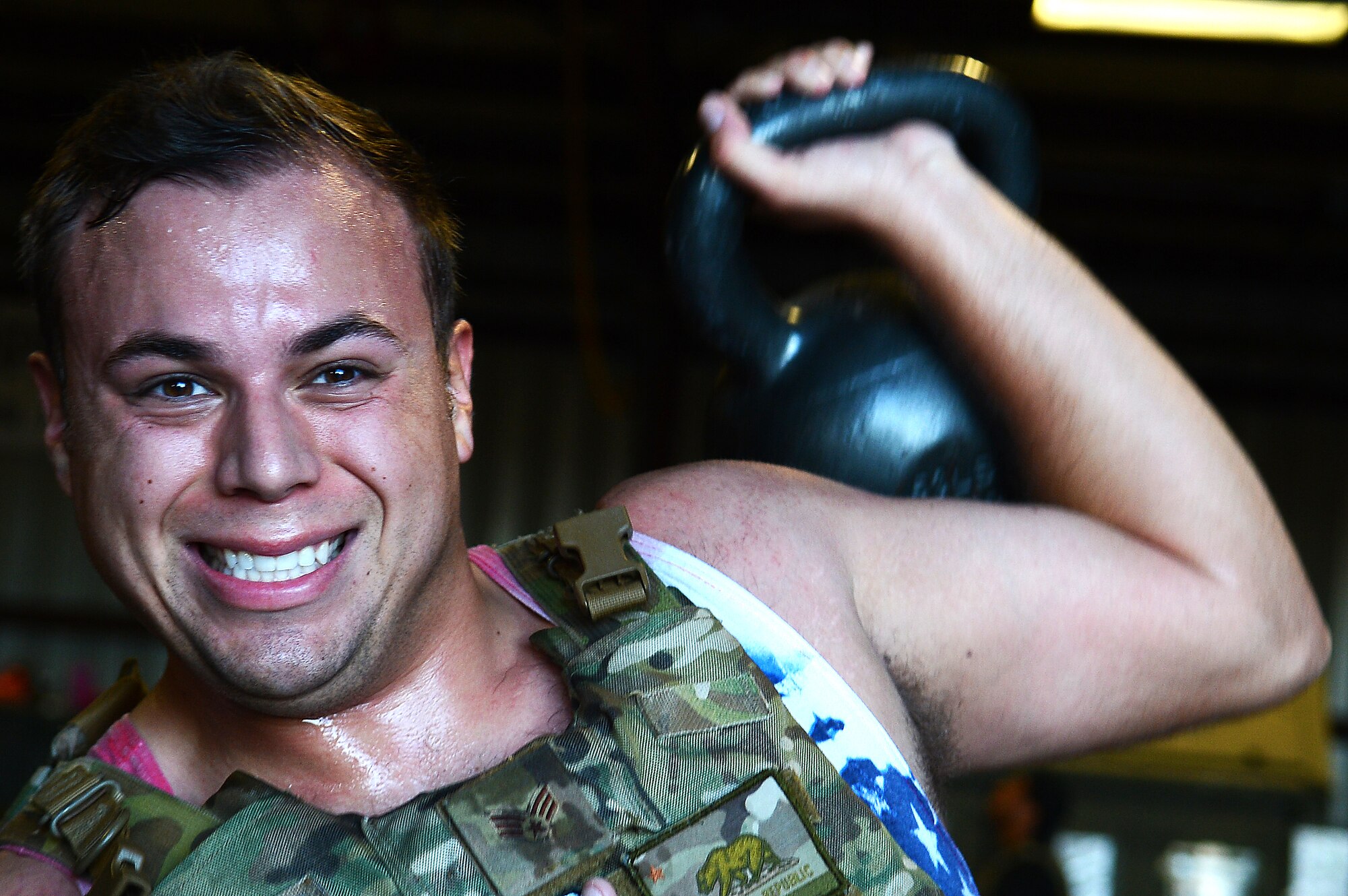 U.S. Air Force Senior Airman Adrian McCoy 20th Civil Engineer Squadron Explosive Ordnance Disposal flight apprentice, attempts a kettlebell raise during the EOD 130 Memorial Workout at Shaw Air Force Base, S.C., Oct. 15, 2015. More than $700 was raised for the EOD Warrior Foundation, a non-profit organization dedicated to providing financial assistance and support to active duty and veteran EOD warriors and their families and maintaining the EOD Memorial Wall, Eglin AFB, Fla. (U.S. Air Force photo by Senior Airman Jonathan Bass/Released)