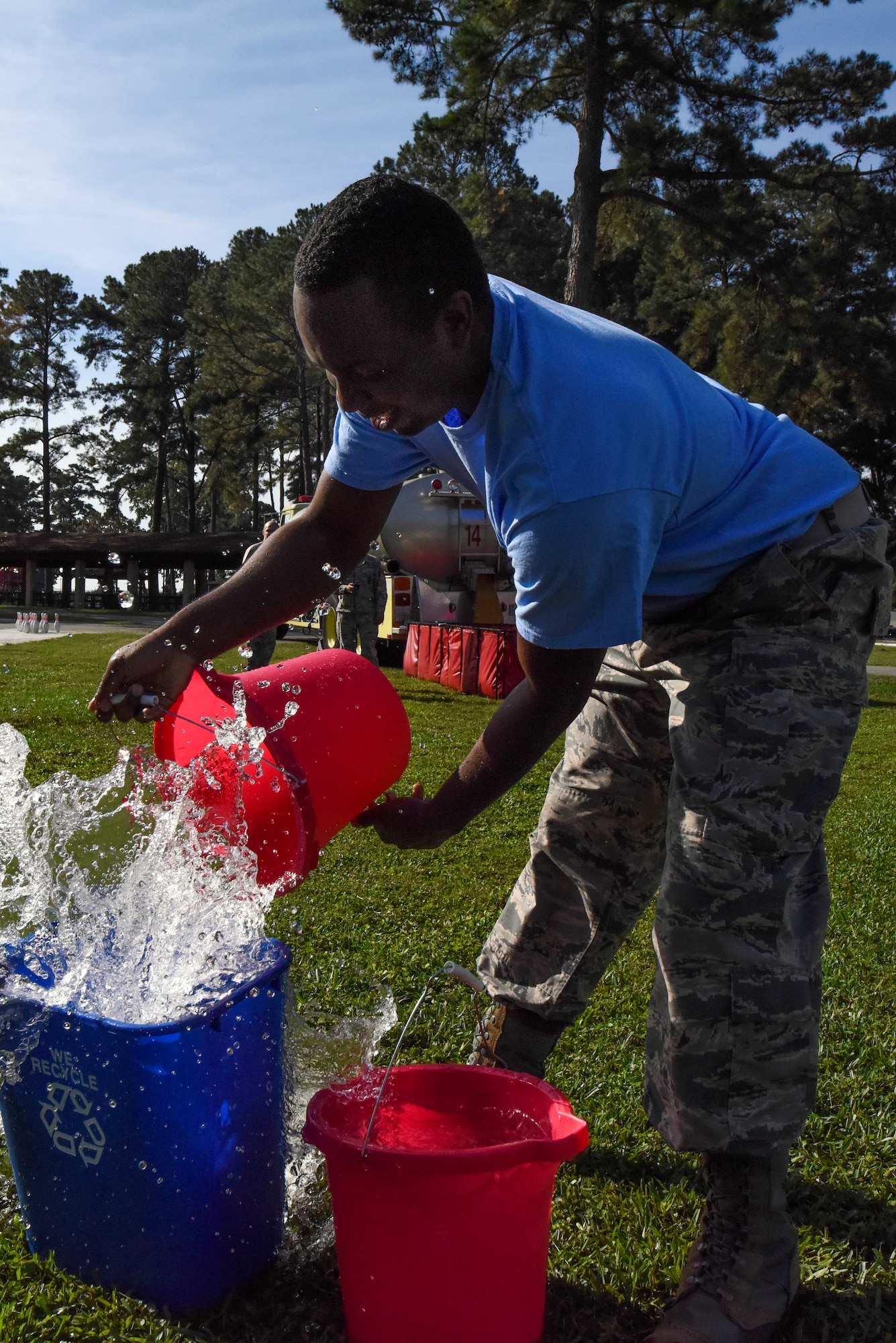 Staff Sgt. Michael Charles, 4th Fighter Wing Public Affairs NCO in charge of community relations, fills a recycling bin with water during a firefighter challenge as part of Fire Prevention Week, Oct. 9, 2015, at Seymour Johnson Air Force Base, North Carolina. During this portion of the challenge, competitors had to race back and forth with buckets of water to fill the recycling bin and cause an action figure to overflow. (U.S. Air Force photo/Senior Airman Brittain Crolley)