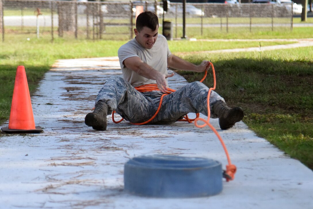 Airman 1st Class Nathan Banden, 4th Civil Engineer Squadron explosive ordnance disposal technician, pulls a fire hose during a firefighter challenge as part of Fire Prevention Week, Oct. 9, 2015, at Seymour Johnson Air Force Base, North Carolina. During the challenge, competitors completed five obstacles, to include a fire hose pull and hammering a Keiser sled. (U.S. Air Force photo/Senior Airman Brittain Crolley)