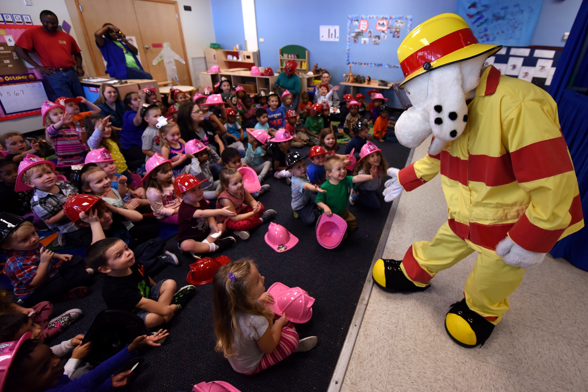 Sparky, 4th Civil Engineer Squadron fire department mascot, high-fives children at the Child Development Center following a puppet show as part of Fire Prevention Week, Oct. 8, 2015, at Seymour Johnson Air Force Base, North Carolina. Sparky and the rest of the fire team encouraged children to identify the fire detectors in their houses and to know their family’s fire emergency plan. (U.S. Air Force photo/Senior Airman Brittain Crolley)