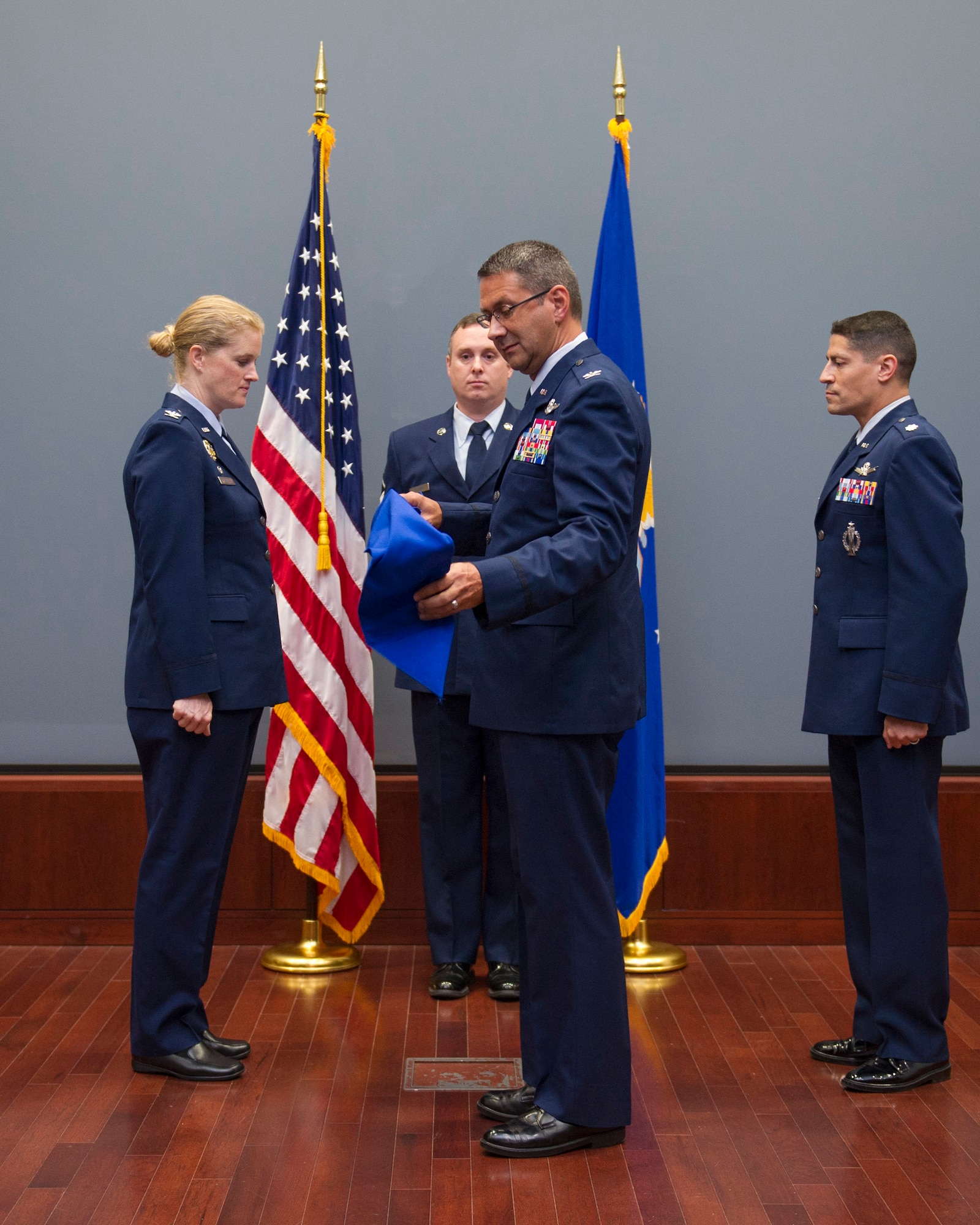 Col. Jonathan VanNoord (center) uncases the guidon for the newly formed Technical Operations Squadron, Air Force Technical Applications Center, Patrick AFB, Fla., as AFTAC's commander, Col. Jennifer P. Sovada (left) and Lt. Col. Robert Light (right) observe.  Light became the first officer to assume command of the new unit at an activation and assumption ceremony in AFTAC's Doyle Northrup Conference Center  Oct. 13, 2015.  (U.S. Air Force photo by Matthew Jurgens)