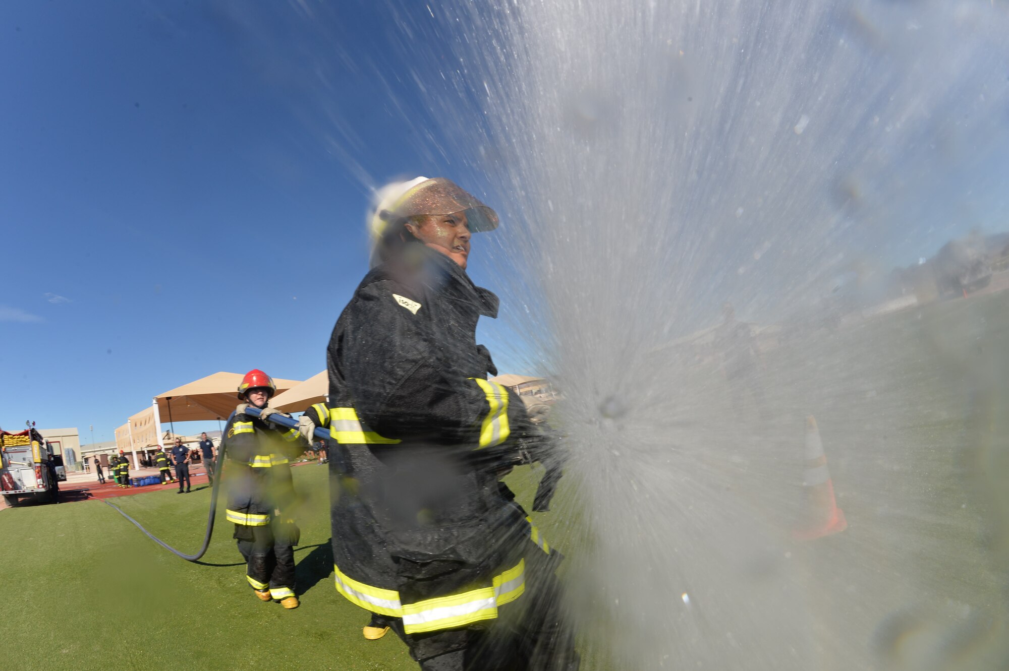 An Airman from Team Creech loses control of the fire hoses at Creech Air Force Base, Nevada, Oct. 9, 2015. The Fire Muster challenge was a part of the Fire Prevention month, 12 teams participated in this challenge. (U.S. Air Force photo by Senior Airman Adarius Petty)