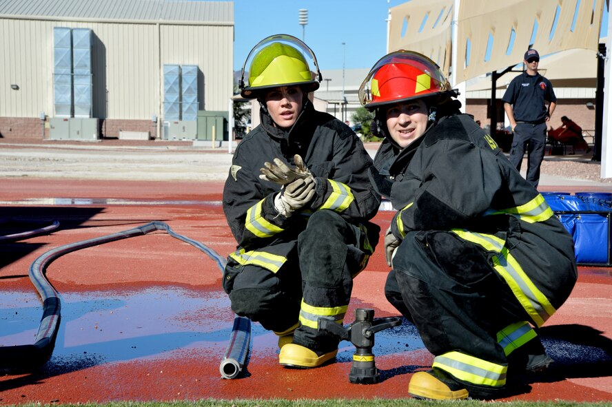 Capt. Sarah Ruckriegle 432nd Wing/432nd Air Expeditionary Wing Public Affairs Chief (,left) Capt. David Stone 432nd Wing/432nd Air Expeditionary Wing Vice Wing commander executive officer, watch their teammates return from an obstacle  at Creech Air Force Base, Nevada, Oct. 9, 2015. Over 12 teams competed in the event, which aims to spread fire prevention awareness through a series of firefighter related challenges. 