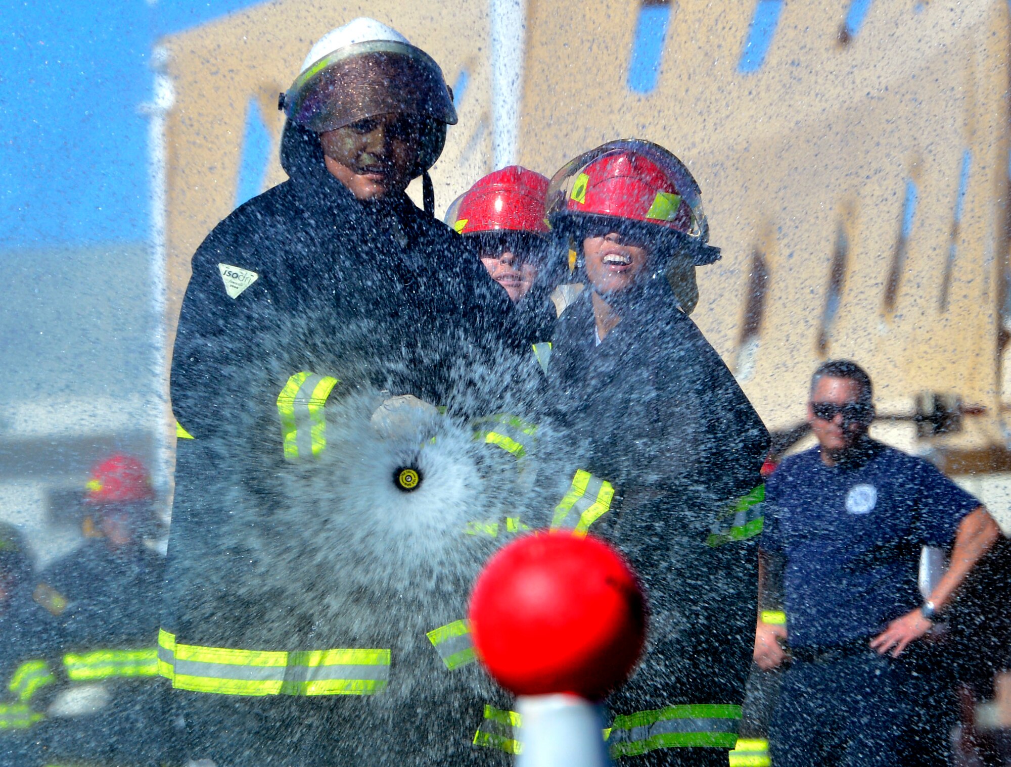A team of participants spray a ball off a cone as part of the 5th annual Fire Muster Oct. 9, 2015, at Creech Air Force Base, Nevada. Over 12 teams competed in the event, which aims to spread fire prevention awareness through a series of firefighter related challenges. (U.S. Air Force photo by Airman 1st Class Christian Clausen/Released)