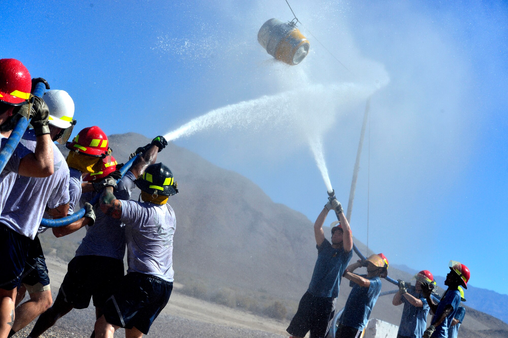 Two teams compete in the finals of the 2015 Fire Muster Oct. 9, 2015, at Creech Air Force Base, Nevada. The teams had to spray a barrel across a line to the other team's side to win. (U.S. Air Force photo by Airman 1st Class Christian Clausen/Released)