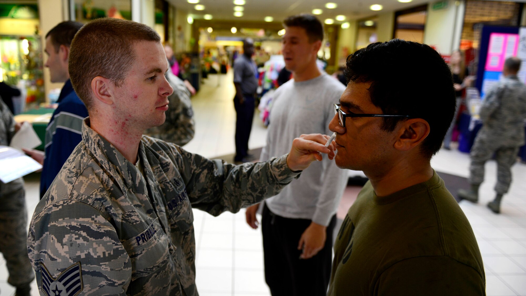 U.S. Air Force Staff Sgt. Justin Pribble, 31st Medical Operations Squadron allergy and immunizations NCO in charge, gives the FluMist to Senior Airman Jose Padro-Hernandez, Oct. 15, 2015, at Aviano Air Base, Italy. The vaccination is required for all uniformed personnel and civilian healthcare employees working in patient care to help prevent from contracting influenza. (U.S. Air Force photo by Senior Airman Areca T. Bell/Released)                                                                                                                                                                                                                                                                                                                                                                                                                                                                                           