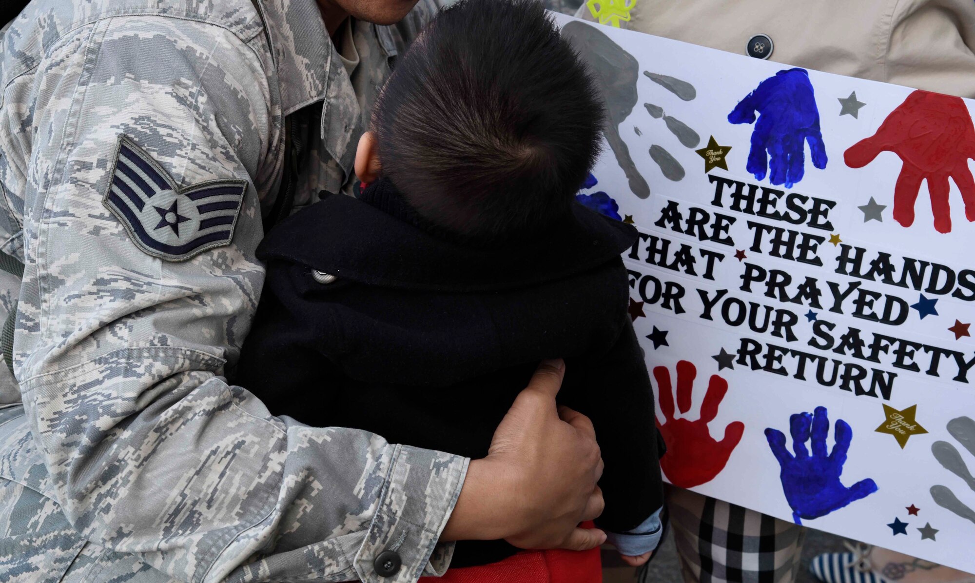 A U. S. Air Force Airman embraces a family member at Misawa Air Base, Japan, Oct. 16, 2015. Airmen were greeted by spouses, friends, and coworkers upon returning from a deployment supporting worldwide operations. (U.S. Air Force photo by Airman 1st Class Jordyn Fetter/Released)