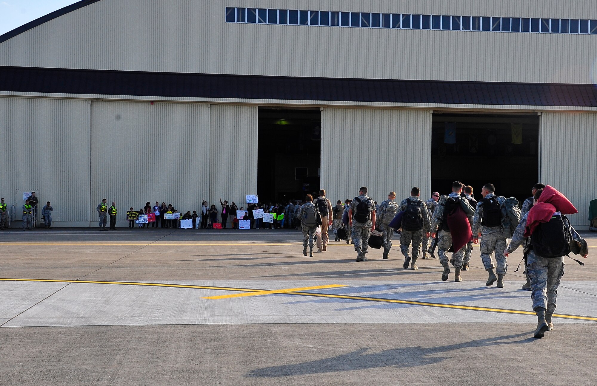 The 35th Fighter Wing Airmen returning from deployment walk toward the nearby hangar where family and friends have gathered to welcome them home at Misawa Air Base, Japan, Oct. 16, 2015.  The family members of the returning units support each other during rotational deployments, creating strong bonds between Misawa AB families. (U.S. Air Force photo by Tech. Sgt. April Quintanilla/Released)