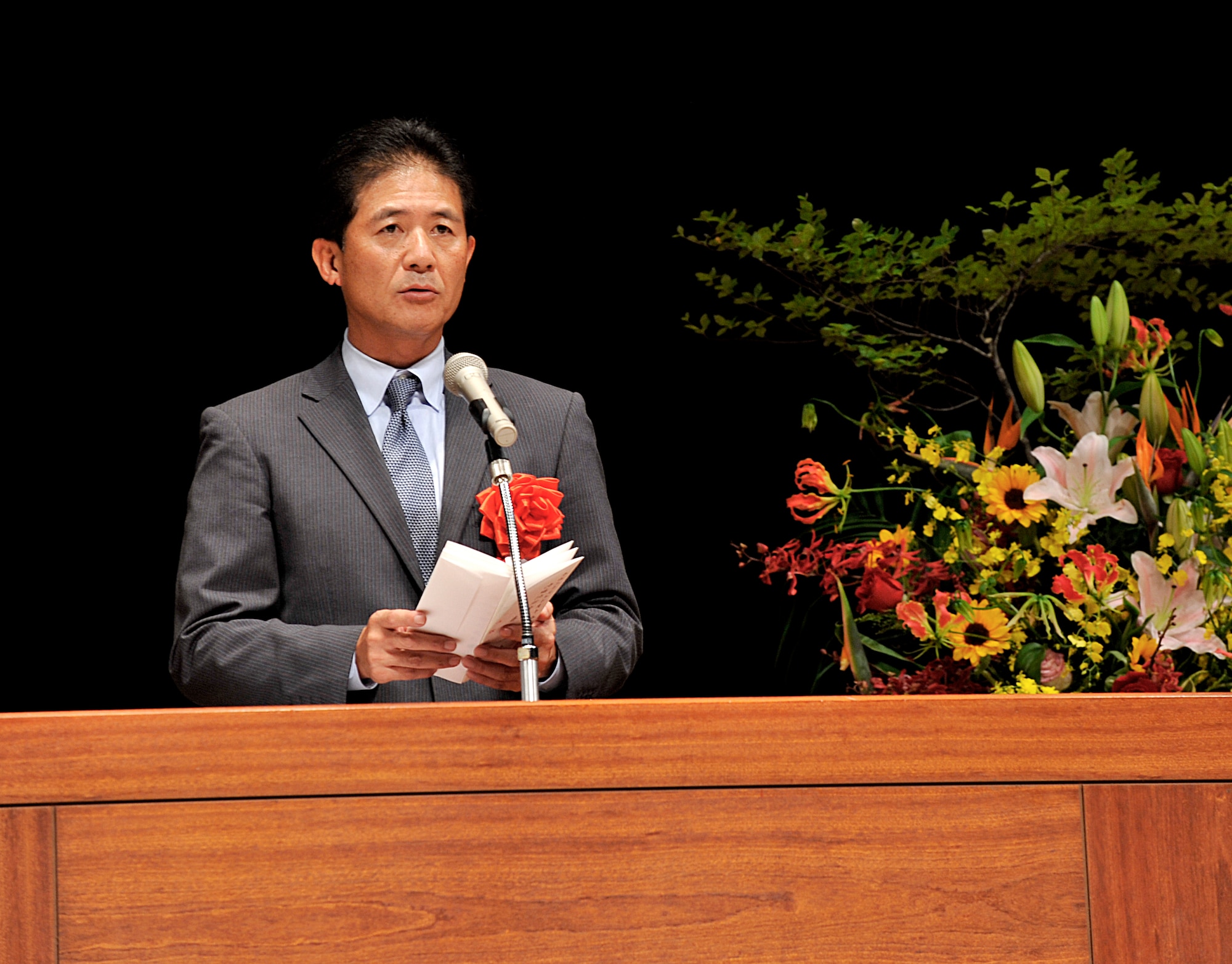 Kazunori Inoue, Okinawa Defense Director, gives opening remarks during a Joint Length of Service Award ceremony at the Okinawa Convention Center in Ginowan City, Japan, Oct. 15, 2015. The Joint Length of Service Award is the award to express gratitude to every U.S. Forces, Japan civilian employee who has 10, 20, 30 or 40 years of service with the USFJ. (U.S. Air Force photo by Naoto Anazawa)
