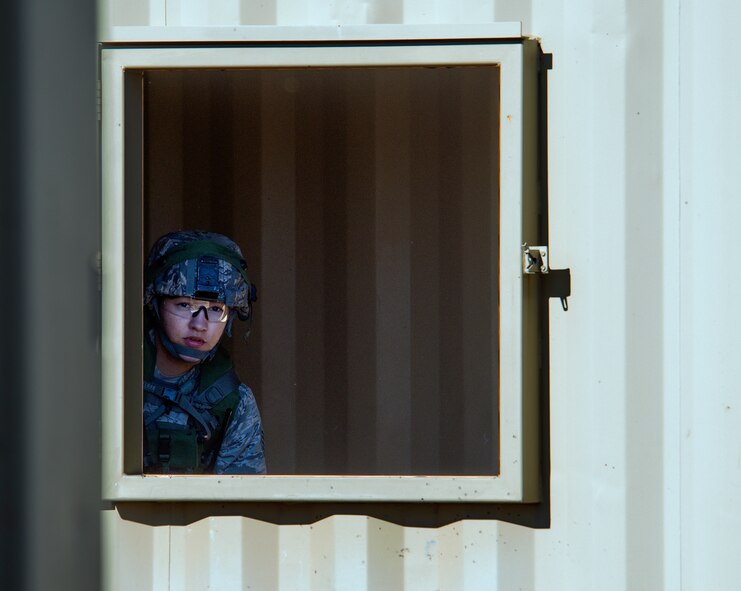 Staff Sgt. Amaris Serrano, 28th Security Forces Squadron Base Defense Operations Center controller, observes during the tactical recapture portion of the 2015 Global Strike Challenge security forces competition at Camp Guernsey, Wyo., Sept. 24, 2015. Airmen used windows as vantage points to survey locations prior to entering an enemy-occupied town. (U.S. Air Force photo by Senior Airman Brandon Valle/Released)