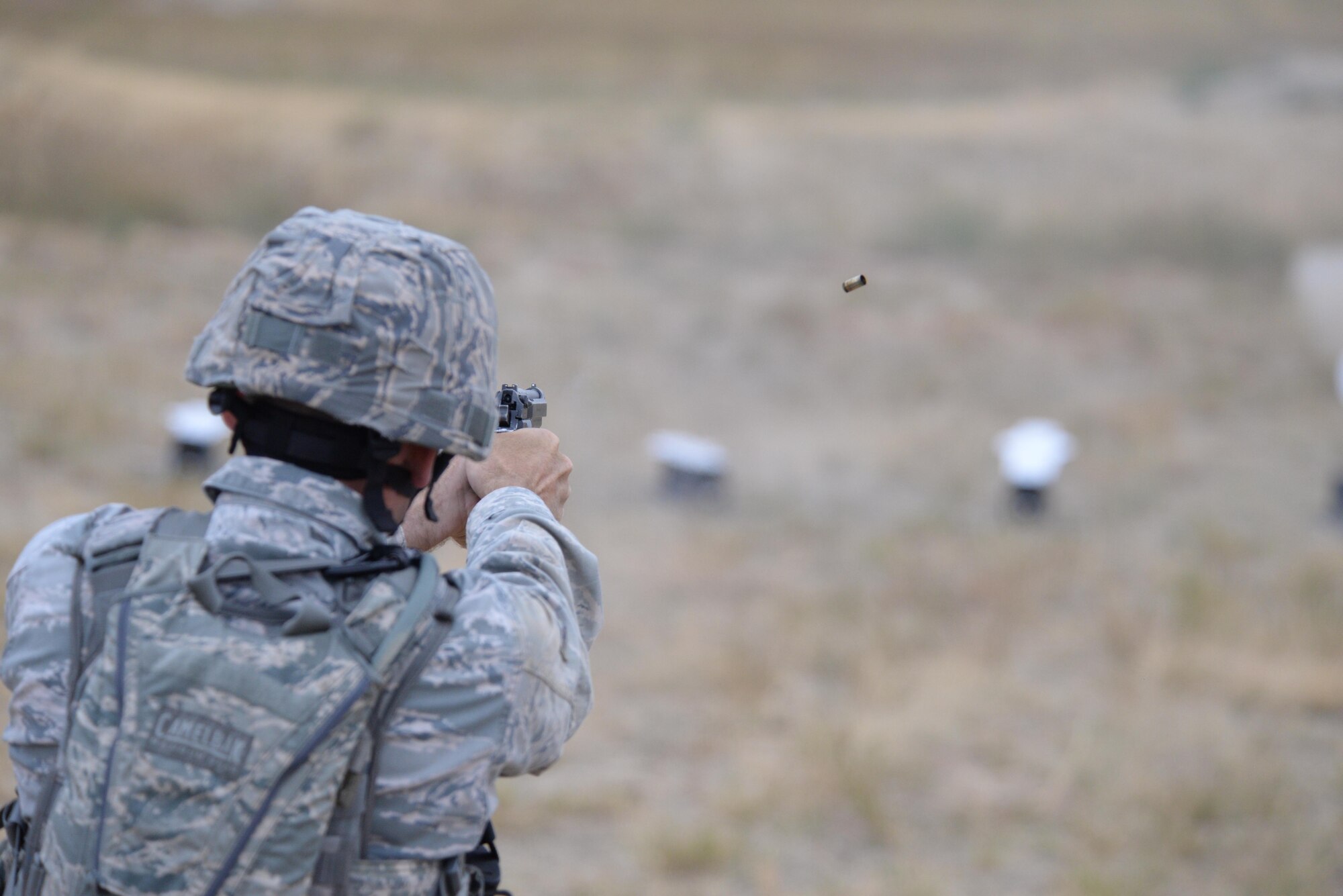 Staff Sgt. Nathan Warren, 28th Security Forces Squadron combat arms instructor, fires an M-9 pistol at a target during the shooting range portion of the 2015 Global Strike Challenge security forces competition at Camp Guernsey, Wyo., Sept. 23, 2015. Competitors accumulated points for the number of targets hit and how quickly they finished the course. (U.S. Air Force photo by Senior Airman Brandon Valle/Released)