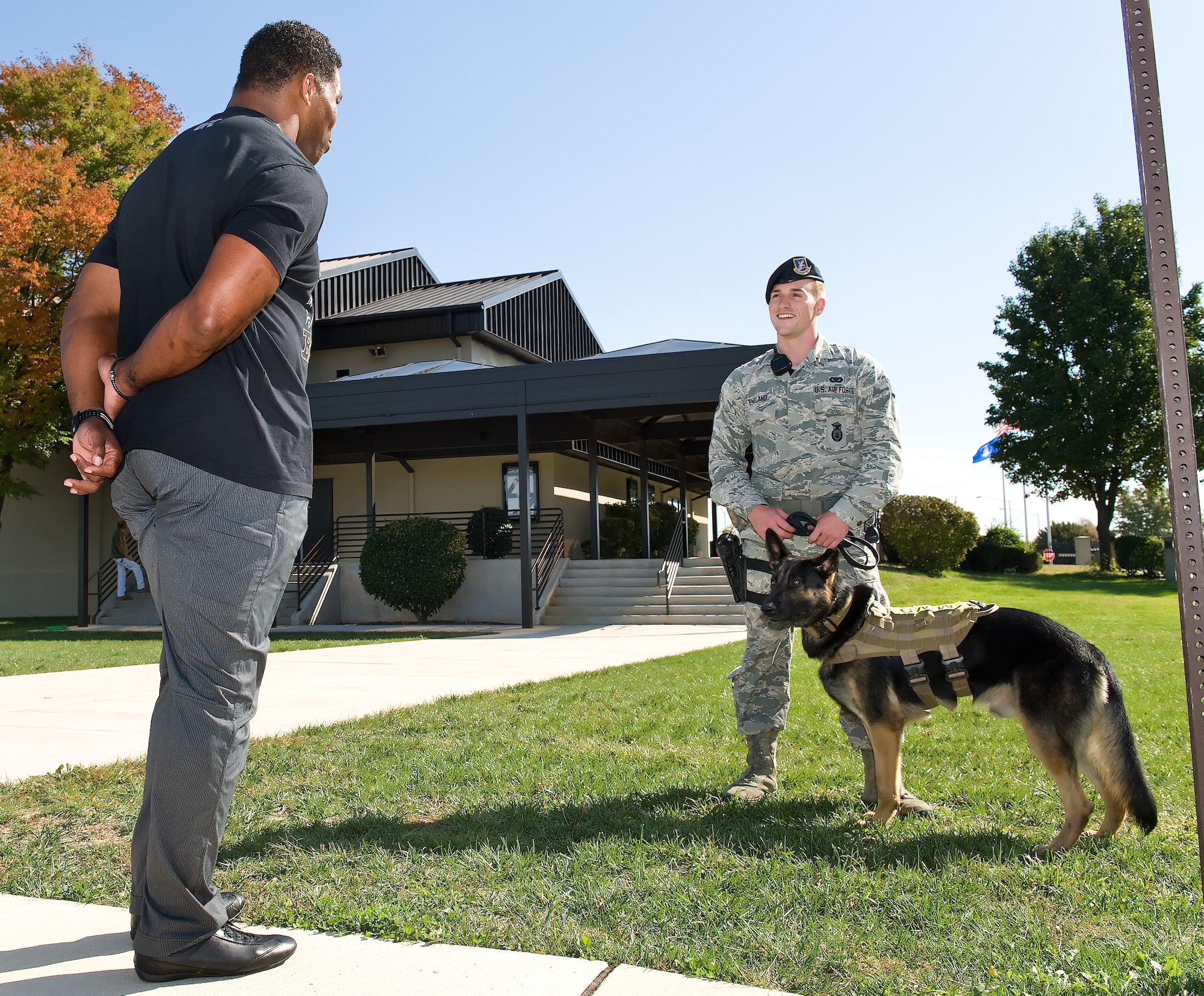 Herschel Walker, left, chats with Staff Sgt. Craig Eveland, 436th Security Forces Squadron military working dog handler and MWD Ramos Oct. 13, 2015, on Dover Air Force Base, Del. Walker, in partnership with the Patriot Support Program's Anti-stigma campaign, visited the base to help spread the message to Team Dover members during Wingman Day advocating to Airmen that it is OK to ask for help through behavioral health services. (U.S. Air Force photo/Roland Balik)