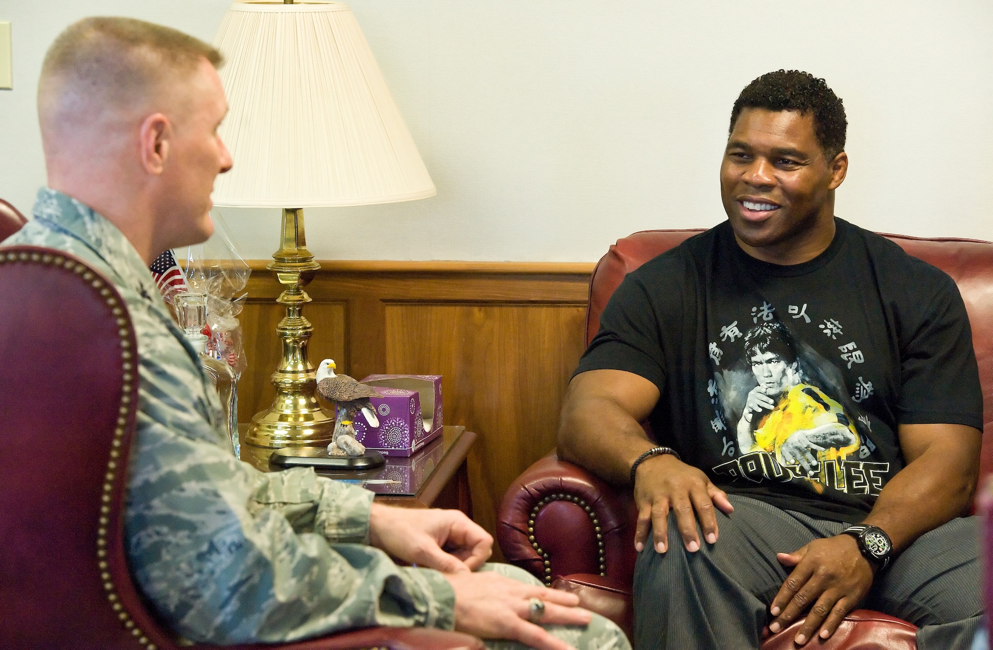 Former NFL running back and 1982 Heisman Trophy winner Herschel Walker, right, chats with Col. Michael Grismer, 436th Airlift Wing commander, left, Oct. 13, 2015, on Dover Air Force Base, Del. Walker came to meet and talk with members of Team Dover during a 3-day visit to the base that included him speaking at the base theater during Wingman Day by emphasizing to Airmen that it is OK to ask for help from behavioral health professionals. (U.S. Air Force photo/Roland Balik)