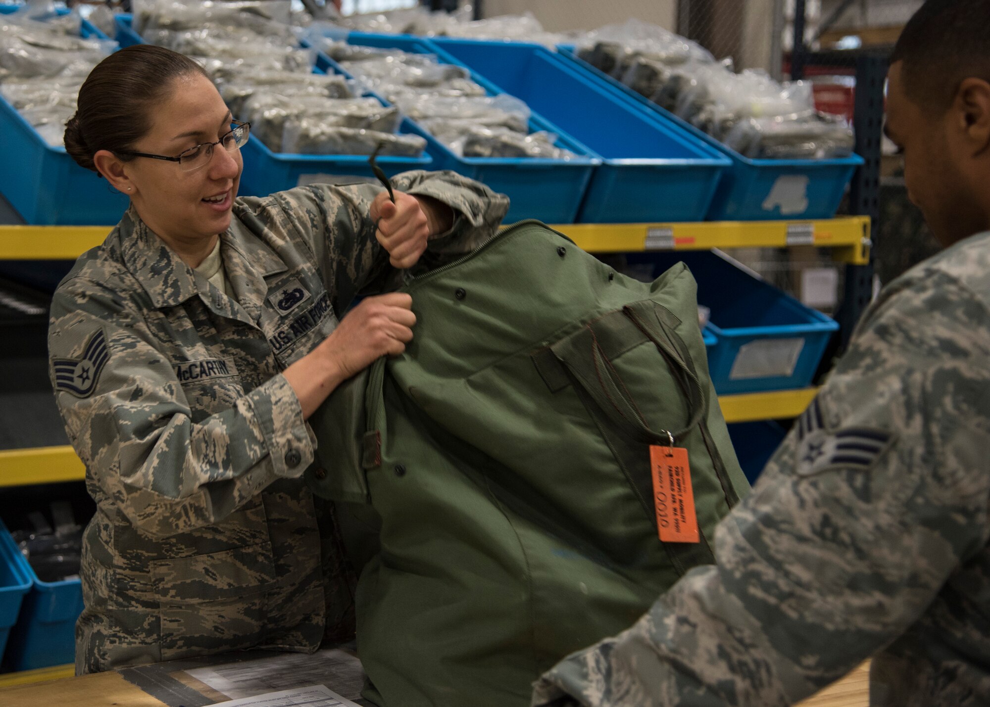 Staff Sgt. Wanda McCarthy 92nd Logistics Readiness Squadron, individual protective equipment supervisor augmentee helps an airman return their equipment Oct. 7, 2015, at Fairchild Air Force Base, Wash. McCarthy is currently augmented to Individual Protection Equipment. She looks through all of the programs and sees how to make any of the processes better and more efficient. Her leadership selected her as one of Fairchild’s Finest, a weekly recognition program that highlights top-performing Airmen. (U.S. Air Force photo/Airman 1st Class Sean Campbell)